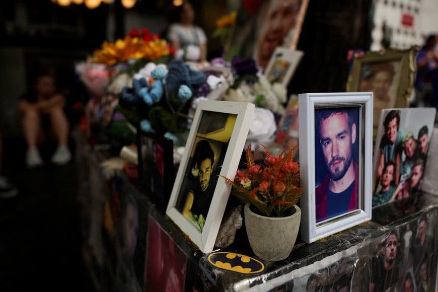 Pictures of former One Direction member Liam Payne are displayed as a fan reacts in the background, during a ceremony marking the first anniversary of his death, held in front of the hotel where he died, in Buenos Aires, Argentina, October 16, 2025. REUTERS/Cristina Sille