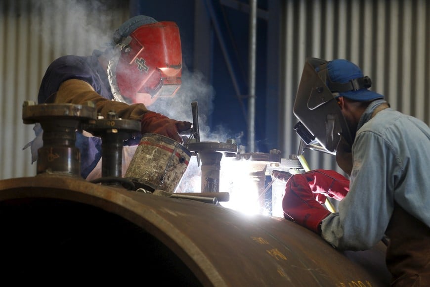 Workers build part of a vessel to be used to transport non-conventional gas, at a factory where state-controlled energy company YPF is refining sand used in fracking, a process by which shale oil and gas is extracted, in Buenos Aires April 16, 2015. The cost of drilling wells in Argentina's vast but barely-tapped Vaca Muerta shale oil and gas formation will fall at least 10 percent by the end of 2016, Miguel Galuccio, chief executive officer of state energy company said on Thursday.    REUTERS/Enrique Marcarian argentina  trabajador YPF utilizacion  fracking fabrica piloto empresa energética estatal YPF refinacion de arena fracking