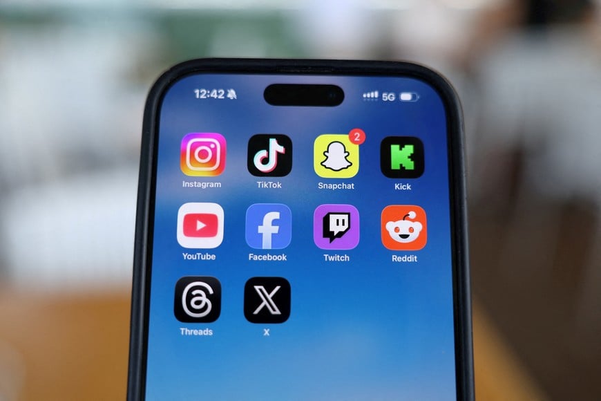 FILE PHOTO: Instagram, TikTok, Snapchat, Kick, YouTube, Facebook, Twitch, Reddit, Threads and X applications are displayed on a mobile phone ahead of new law banning social media for users under 16 in Australia, in this picture illustration taken on December 9, 2025. REUTERS/Hollie Adams/Illustration/File Photo