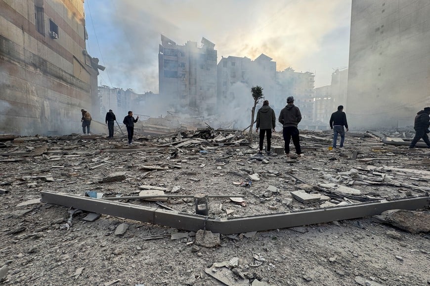 People stand on the rubble of a damaged building after an Israeli strike on Beirut's southern suburbs, following renewed hostilities between Hezbollah and Israel amid the U.S.-Israeli conflict with Iran, in Beirut, Lebanon, March 6, 2026. Picture taken with a mobile phone. REUTERS/Stringer