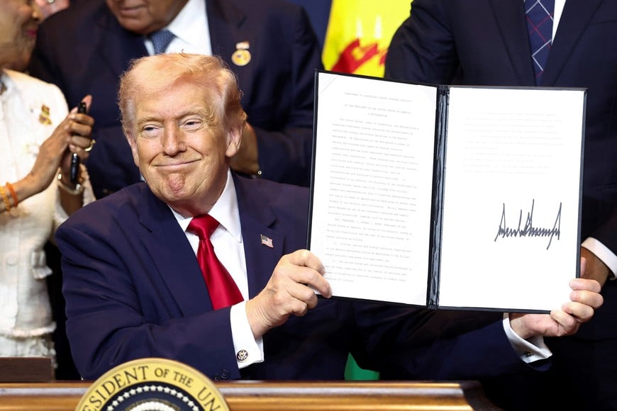 U.S. President Donald Trump reacts as he holds the "Commitment to countering cartel criminal activity" document during the "Shield of the Americas" Summit in Miami, Florida, U.S., March 7, 2026. REUTERS/Kevin Lamarque