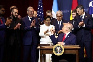 U.S. President Donald Trump reacts after signing the "Commitment to countering cartel criminal activity" document, next to Trinidad and Tobago Prime Minister Kamla Persad-Bissessar, Paraguay's President Santiago Pena, Panama's President Jose Raul Mulino, Dominican Republic President Luis Abinader, Argentina's President Javier Milei and U.S. Secretary of Defense Pete Hegseth during the "Shield of the Americas" Summit in Miami, Florida, U.S., March 7, 2026. REUTERS/Kevin Lamarque