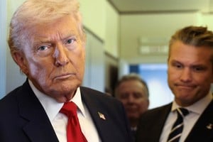 U.S. President Donald Trump, with Secretary of Defense Pete Hegseth at his side, looks on as he speaks to reporters aboard Air Force One on a flight from Dover, Delaware, to Miami, Florida, U.S., March 7, 2026. REUTERS/Kevin Lamarque     TPX IMAGES OF THE DAY