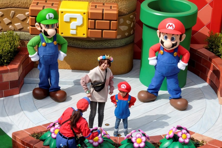 Mario and Luigi characters greet visitors in front of Yoshi's Adventure attraction inside Super Nintendo World, a new attraction area featuring the popular video game character Mario which is set to open to public on March 18, during a press preview at the Universal Studios Japan theme park in Osaka, western Japan, March 17, 2021. Picture taken March 17, 2021.  REUTERS/Irene Wang