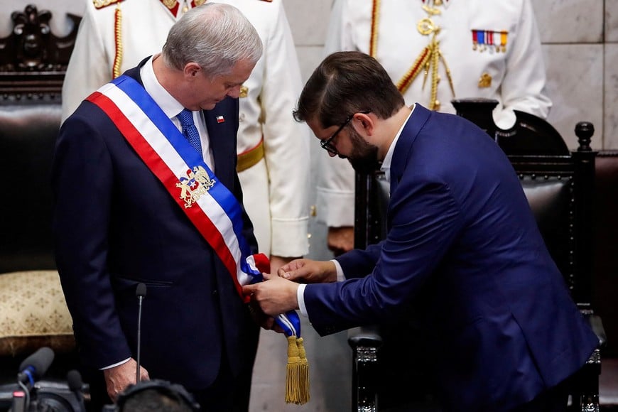 Chile's former President Gabriel Boric helps adjust Chile's President Jose Antonio Kast's presidential sash, during Kast's swearing-in ceremony, at the Congress, in Valparaiso, Chile, March 11, 2026. REUTERS/Rodrigo Garrido