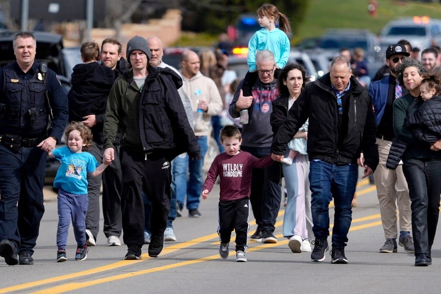 Parents are escorted by police down Walnut Lake Road back to their cars after being reunited with their children after a suspect crashed his truck into the hallway of Temple Israel synagogue in West Bloomfield, Michigan, U.S., March 12, 2026.   Eric Seals/USA Today Network via REUTERS.   
NO RESALES. NO ARCHIVES. THIS IMAGE HAS BEEN SUPPLIED BY A THIRD PARTY