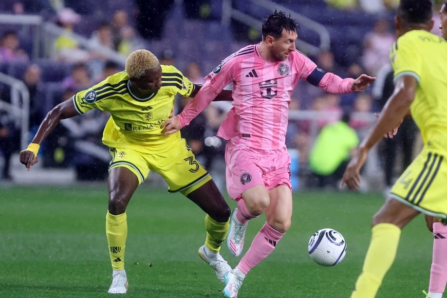 Mar 11, 2026; Nashville, Tennessee, USA; Inter Miami CF forward  Lionel Messi (10) attacks as Nashville SC defender Maxwell Woledzi (3) defends during their 2026 Concacaf Champions Cup Round of 16 Leg 1 game at GEODIS Park. Mandatory Credit: Alan Poizner-Imagn Images