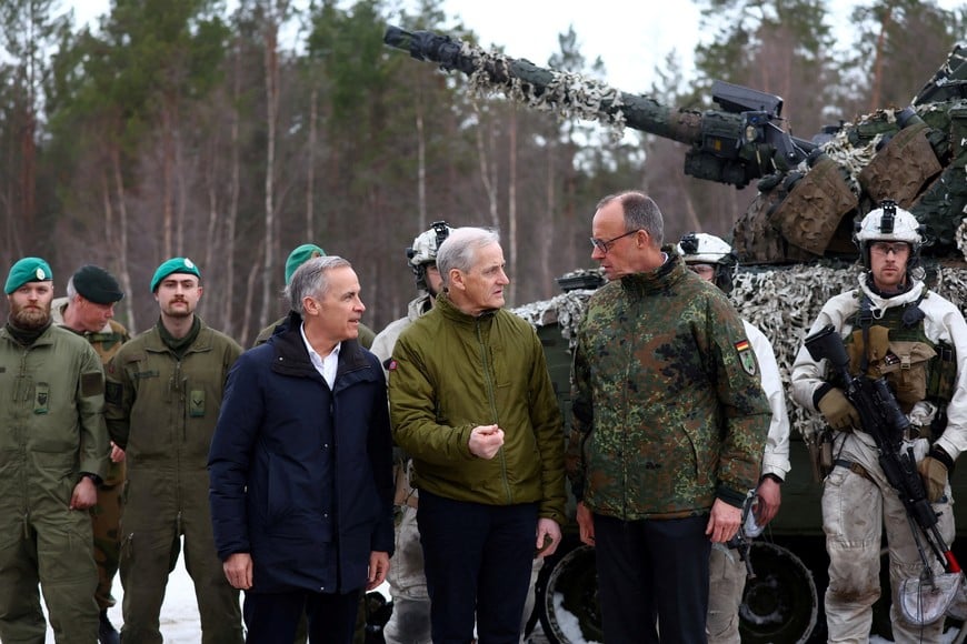 Canadian Prime Minister Mark Carney, Norwegian Prime Minister Jonas Gahr Stoere and German Chancellor Friedrich Merz talk after a military exercise during the NATO Cold Response drills near Bardufoss, in Arctic Norway, March 13, 2026. REUTERS/Bernadett Szabo