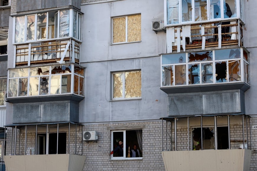 Residents remove debris from an apartment in a building damaged during overnight Russian missile and drone strikes, amid Russia's attack on Ukraine, in the town of Brovary, Kyiv region, Ukraine March 14, 2026. REUTERS/Valentyn Ogirenko     TPX IMAGES OF THE DAY