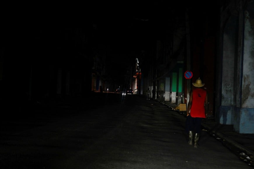 A man walks along a street during a blackout before Cuba's President Miguel Diaz-Canel's announcement on state television that the country has opened talks with the U.S. government amid a severe economic crisis and as the Communist government has come under increasing pressure from U.S. President Donald Trump, in Havana, Cuba, March 13, 2026. REUTERS/Norlys Perez