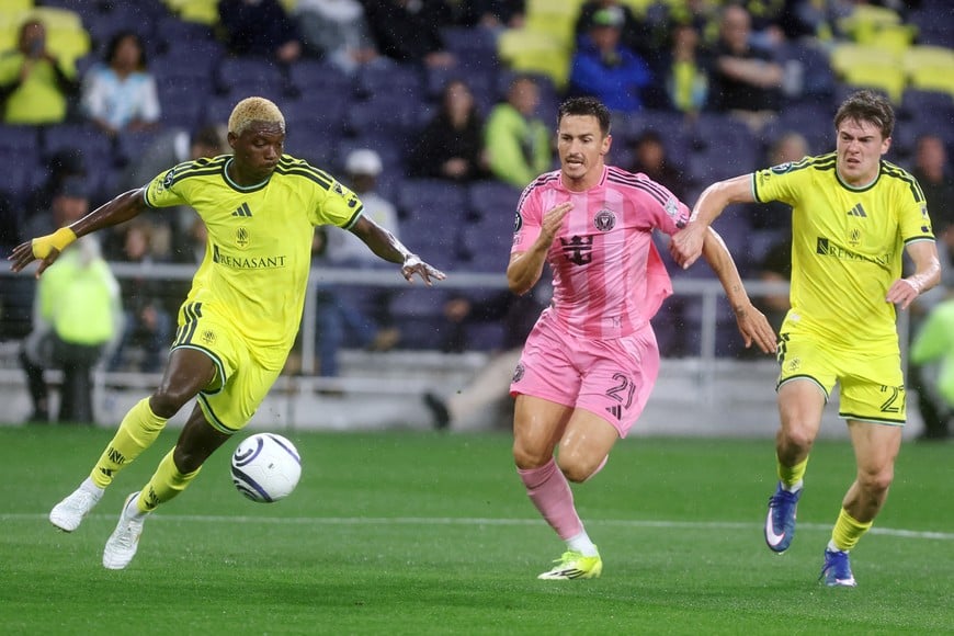Mar 11, 2026; Nashville, Tennessee, USA; Nashville SC defender Maxwell Woledzi (3) and Nashville SC defender/midfielder Reed Baker-Whiting (27) defend as Inter Miami CF forward Tadeo Allende (21) attacks during their 2026 Concacaf Champions Cup Round of 16 Leg 1 game at GEODIS Park. Mandatory Credit: Alan Poizner-Imagn Images