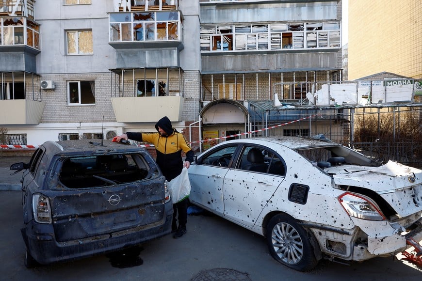 A resident stands next to his car damaged during overnight Russian missile and drone strikes, amid Russia's attack on Ukraine, in the town of Brovary, Kyiv region, Ukraine March 14, 2026. REUTERS/Valentyn Ogirenko
