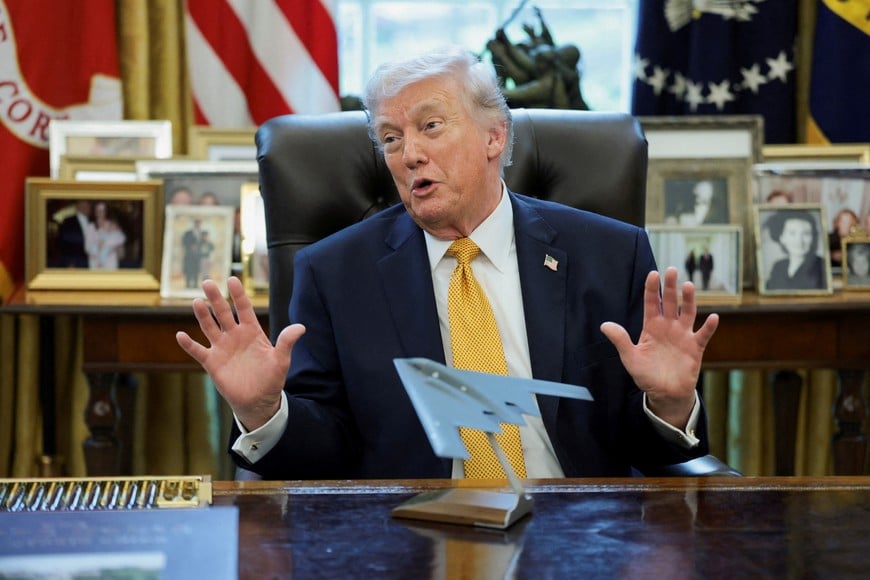 U.S. President Donald Trump gestures in front of a model of a B-2 bomber commemorating "Operation Midnight Hammer" during an event to sign an executive order creating an anti-fraud task force headed by U.S. Vice President JD Vance in the Oval Office at the White House in Washington, D.C., U.S., March 16, 2026. REUTERS/Jonathan Ernst