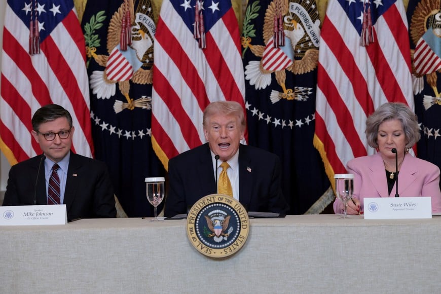 U.S. President Donald Trump, flanked by the Speaker of the House Mike Johnson (R-LA) and White House chief of staff Susie Wiles, speaks during a lunch with the Kennedy Center board members in the East Room of the White House in Washington, D.C., U.S., March 16, 2026. REUTERS/Jonathan Ernst