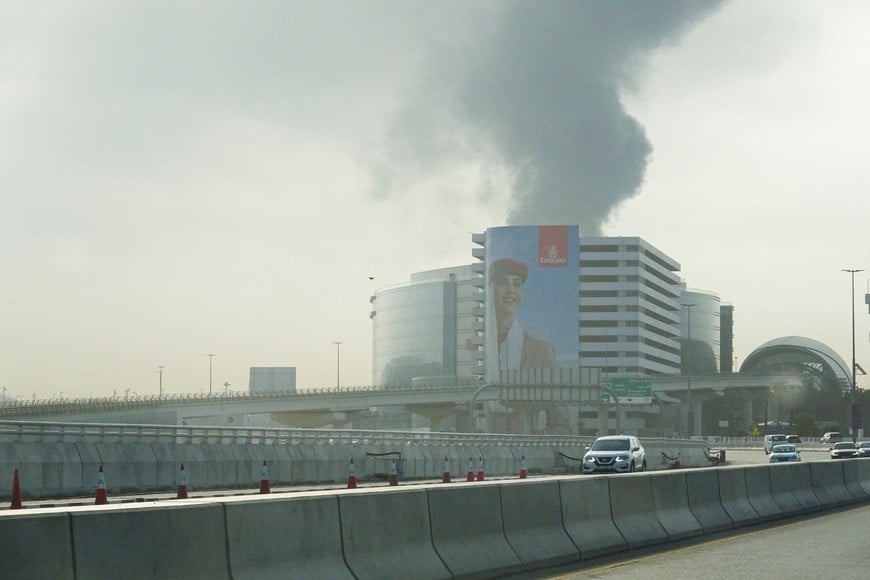 Smoke rising from the Dubai International Airport is seen through the windshield of a vehicle, after a drone attack hit a fuel tank, according to Dubai authorities, amid the U.S.-Israel conflict with Iran, in Dubai, United Arab Emirates, March 16, 2026, REUTERS/Stringer