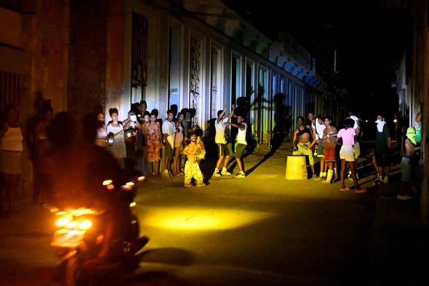 People gather on a street during a blackout as Cuba's national electric grid collapsed, according to the country's grid operator, leaving around 10 million people without power amid a U.S.-imposed oil blockade, in Havana, Cuba March 16, 2026. REUTERS/Norlys Perez