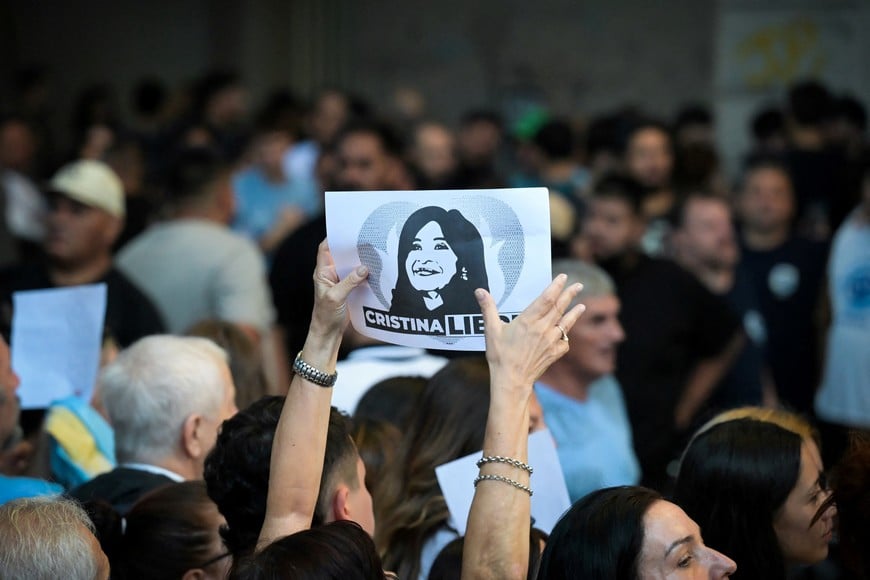 A person holds a sign with an image of Argentina's former President Cristina Fernandez de Kirchner as supporters gather outside her residence, where she is currently staying under house arrest, on the day she attends a hearing in the "Causa Cuadernos" corruption trial, after being summoned to testify following the rejection of defense motions seeking to nullify the proceedings, in Buenos Aires, Argentina, March 17, 2026. REUTERS/Martin Cossarini