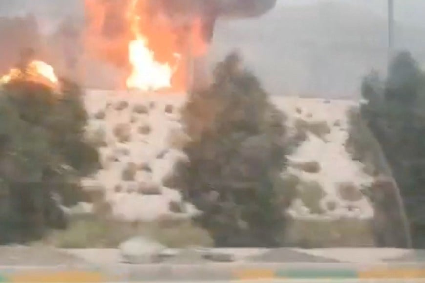 Smoke and flames rise from the South Pars gas field following an Israeli strike, as seen through the window of a moving vehicle, amid the U.S.-Israeli conflict with Iran, in Asaluyeh, Bushehr Province, Iran, March 18, 2026, in this screen grab obtained from social media video. Social Media/via REUTERS  THIS IMAGE HAS BEEN SUPPLIED BY A THIRD PARTY. NO RESALES. NO ARCHIVES.

VERIFICATION:
- Road layout, car port, toll booths and trees matched satellite imagery.
- Coordinates: 27.52556946527111, 52.568484893686
- Iranian media, Fars news agency, reported tanks and gas facilities in South Pars refinery in Asaluyeh, Iran, were hit on March 18.
- No older versions of the video were found posted online before March 18.