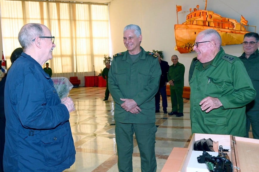 Cuba's folk singer Silvio Rodriguez, next to Cuban President Miguel Diaz-Canel, is presented with an AKM war rifle and a ceremonial replica by Minister of the Revolutionary Armed Forces Army Corps General Alvaro Lopez, in appreciation for a social media post in which he said he was prepared to take up arms against any U.S. invasion, during a ceremony at the Ministry of the Revolutionary Armed Forces (MINFAR), in Havana, Cuba, March 20, 2026. Cuba Presidency/Handout via REUTERS ATTENTION EDITORS - THIS IMAGE HAS BEEN SUPPLIED BY A THIRD PARTY. NO RESALES. NO ARCHIVES