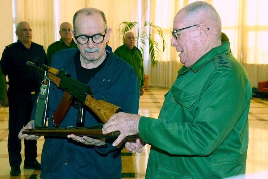 Cuba's folk singer Silvio Rodriguez is presented with an AKM war rifle and a ceremonial replica by Minister of the Revolutionary Armed Forces Army Corps General Alvaro Lopez, in appreciation for a social media post in which he said he was prepared to take up arms against any U.S. invasion, during a ceremony attended by Cuban President Miguel Diaz-Canel at the Ministry of the Revolutionary Armed Forces (MINFAR), in Havana, Cuba, March 20, 2026. Cuba Presidency/Handout via REUTERS ATTENTION EDITORS - THIS IMAGE HAS BEEN SUPPLIED BY A THIRD PARTY. NO RESALES. NO ARCHIVES
