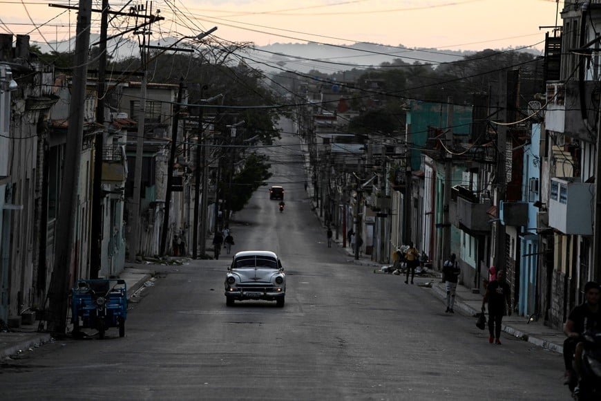 A vintage car drives along an empty street as Cuba begins efforts to restore power after its grid collapsed for the second time in a week, amid a U.S. oil blockade that has dealt a major blow to the island's already ailing energy infrastructure, in Havana, Cuba March 22, 2026. REUTERS/Norlys Perez
