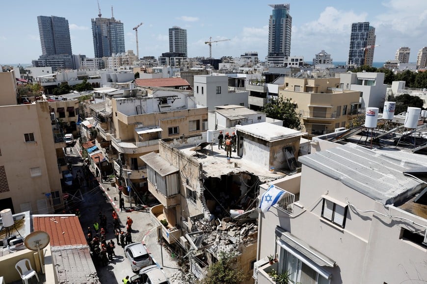 Israeli soldiers inspect the site of a damaged building following barrages of Iranian missiles, amid the U.S.-Israeli conflict with Iran, in Tel Aviv, Israel, March 22, 2026. REUTERS/Amir Cohen