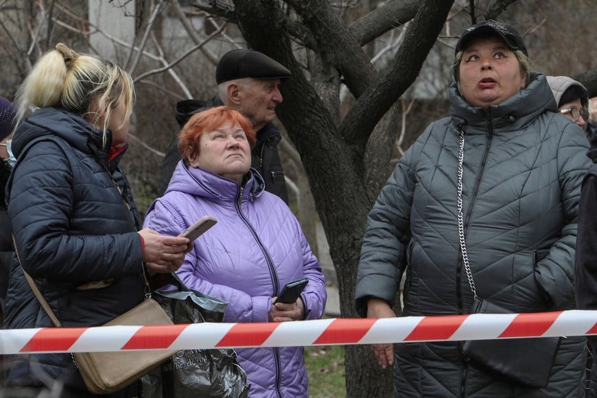 Residents look at their apartment building which was hit by a Russian drone strike, amid Russia's attack on Ukraine, in Dnipro, Ukraine March 24, 2026. REUTERS/Stringer