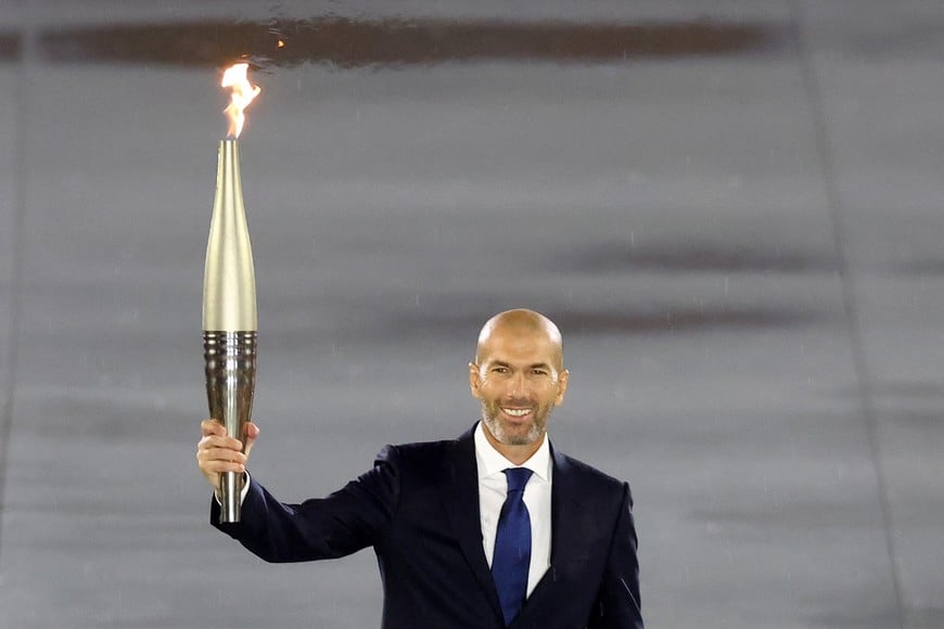 Paris 2024 Olympics - Opening Ceremony - Paris, France - July 26, 2024. 
Former France footballer Zinedine Zidane carries the Olympic torch during the opening ceremony REUTERS/Hannah Mckay