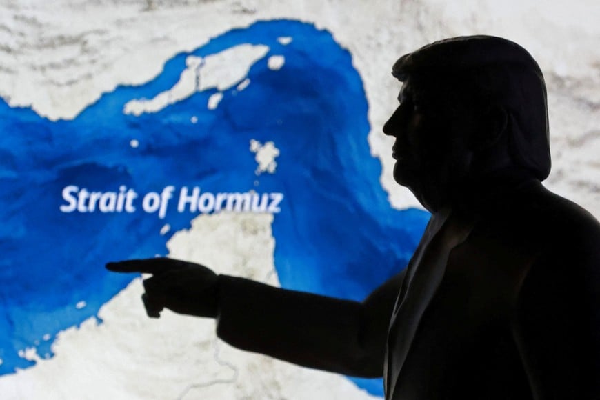 A map showing the Strait of Hormuz and a 3D-printed miniature model depicting U.S. President Donald Trump are seen in this illustration taken March 23, 2026. REUTERS/Dado Ruvic/Illustration