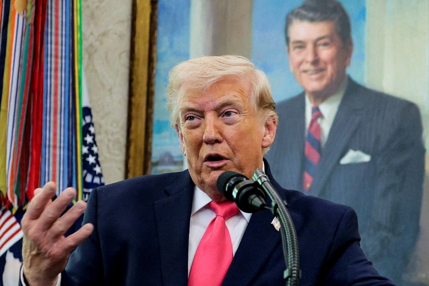 U.S. President Donald Trump speaks, with a portrait of former U.S. President Ronald Reagan in the background, as he attends Markwayne Mullin's swearing-in as Department of Homeland Security (DHS) Secretary, at the White House in Washington, D.C., U.S., March 24, 2026. REUTERS/Evan Vucci     TPX IMAGES OF THE DAY