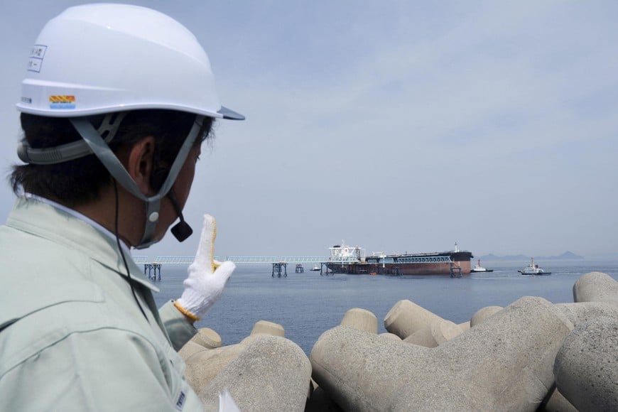 An official gives lectures on the crude oil release operation as a tanker is moored at the Shirashima National Petroleum Stockpiling Base in Kitakyushu, southwestern Japan, March 27, 2026, as the Japanese government started releasing state-held oil to stabilise supplies, amid the U.S.-Israeli conflict with Iran, in this photo taken by Kyodo. Mandatory credit Kyodo/via REUTERS ATTENTION EDITORS - THIS IMAGE HAS BEEN SUPPLIED BY A THIRD PARTY. MANDATORY CREDIT. JAPAN OUT. NO COMMERCIAL OR EDITORIAL SALES IN JAPAN.