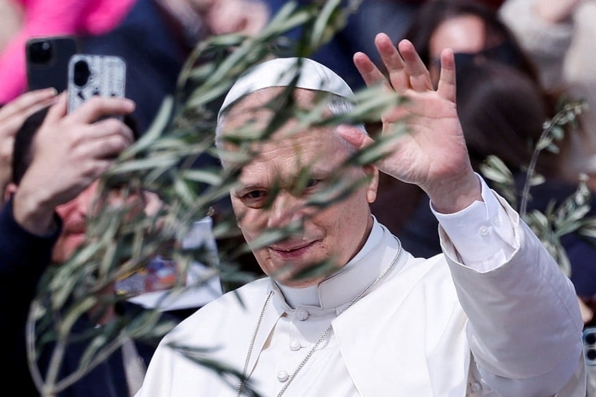 Pope Leo XIV waves as he rides past people holding branches after Palm Sunday Mass in Saint Peter's Square at the Vatican, March 29, 2026. REUTERS/Remo Casilli