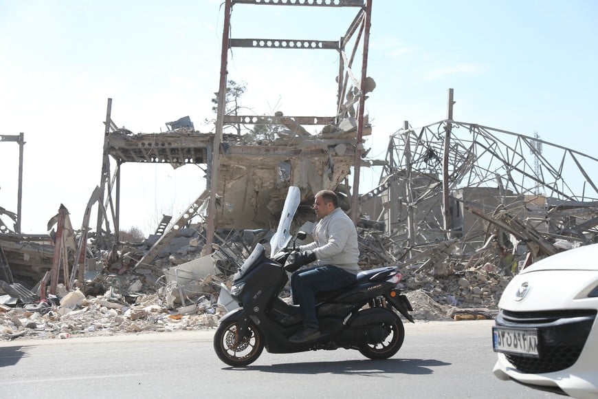 (260330) -- BEIJING, 30 marzo, 2026 (Xinhua) -- Imagen del 4 de marzo de 2026 de un hombre circulando en una motocicleta frente a edificios destruidos, en Teherán, Irán. El conflicto entre Estados Unidos e Israel contra Irán entró a su día 30 el domingo, sin que se vislumbre el fin de la guerra. Las personas en Teherán y Tel Aviv vivieron día y noche entre sirenas y explosiones, enfrentándose a la devastación causada por el conflicto mientras anhelan una vida pacífica. (Xinhua/Shadati) (rtg) (ah) (vf)