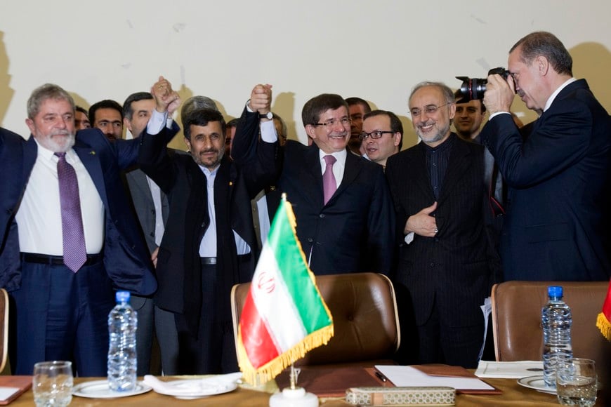 Turkey's Prime Minister Tayyip Erdogan (R) takes a photograph as Iran's President Mahmoud Ahmadinejad (2nd L), his Brazilian counterpart Luiz Inacio Lula da Silva (L) and Turkish Foreign Minister Ahmet Davutoglu (C) hold up their hands as a sign of unity and head of Iran's Atomic Energy Organisation Ali Akbar Salehi (2nd R) smiles after signing an agreement during the 32nd Meeting of the Ministers of Foreign Affairs of G-15 in Tehran May 17, 2010. REUTERS/Morteza Nikoubazl (IRAN - Tags: POLITICS) iran teheran luis inacio lula da silva Mahmoud Ahmadinejad Recep Tayyip Erdogan iran firma acuerdo envio uranio enriquecido a turquia programa nuclear atomico iran presidente de brasil presidente de iran y primer ministro de turquia