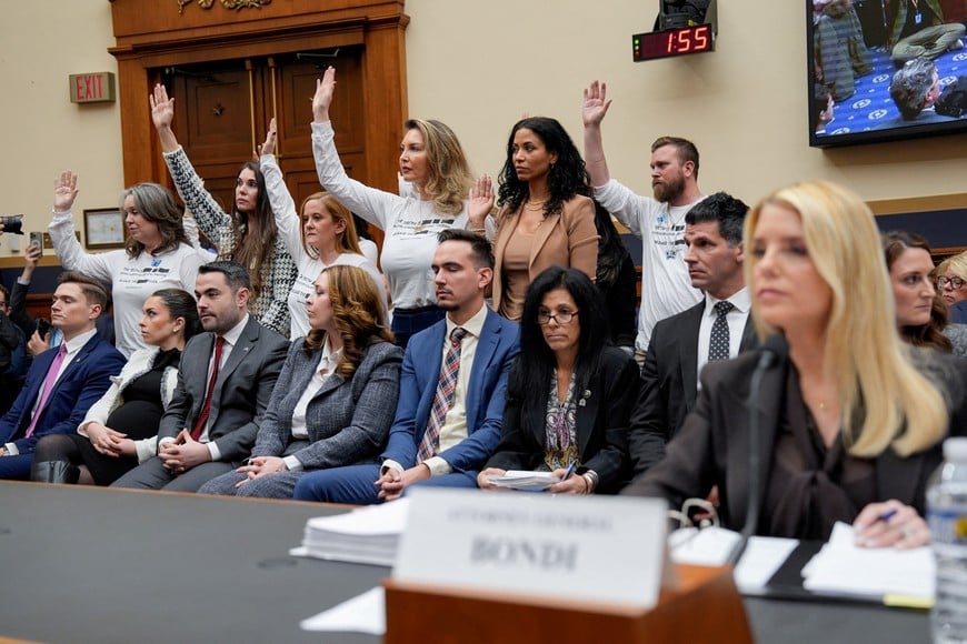 Survivors of Jeffrey Epstein raise their hands after U.S. Representative Pramila Jayapal (D-WA) asked who of them has been unable to meet with the U.S. Department of Justice led by Attorney General Pam Bondi, as Bondi attends a House Judiciary Committee hearing on oversight of the Justice Department to testify, on Capitol Hill in Washington, D.C., U.S., February 11, 2026. REUTERS/Kent Nishimura     TPX IMAGES OF THE DAY