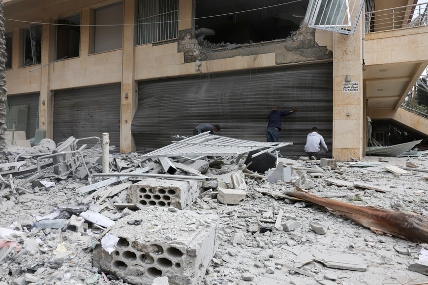 People inspect a building damaged in an Israeli strike on Sunday, amid escalating hostilities between Israel and Hezbollah, as the U.S.-Israel conflict with Iran continues, in Bir Hassan, Beirut, Lebanon, April 6, 2026. REUTERS/Mohamed Azakir