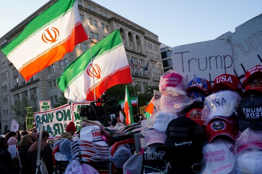 Demonstrators stand near merch in support of U.S. President Donald Trump during a protest against military action in Iran after U.S. President Donald Trump said that he had agreed to a two-week ceasefire with Iran, less than two hours before his deadline for Tehran to reopen the Strait of Hormuz or face widespread attacks on its civilian infrastructure, outside the White House in Washington, D.C., U.S., April 7, 2026. REUTERS/Nathan Howard