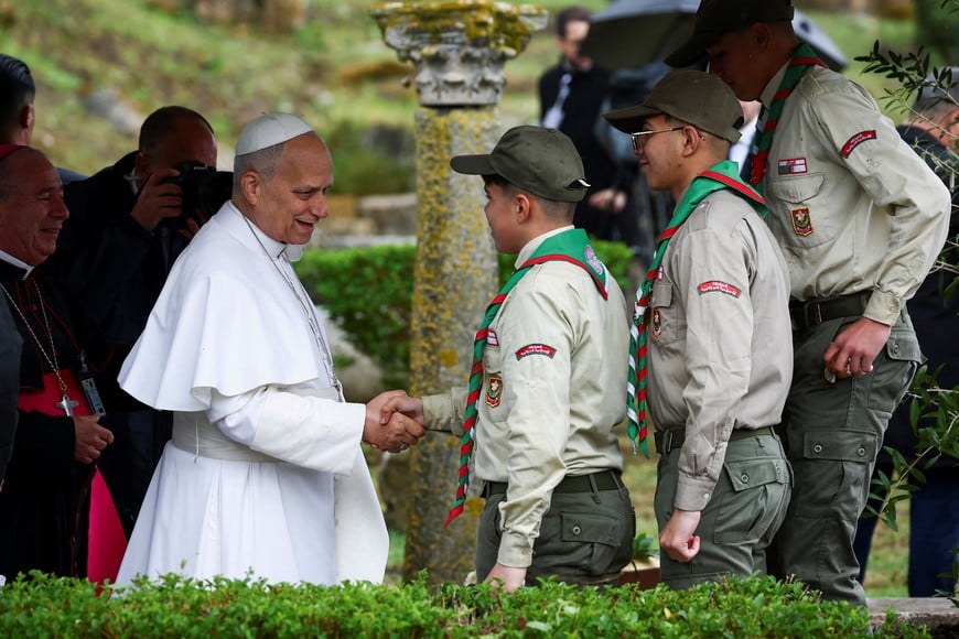 Pope Leo XIV shake hands with the youth who helped him plant a tree during his visit to the archaeological site of Hippo Regius in Annaba, Algeria, April 14, 2026. REUTERS/Guglielmo Mangiapane