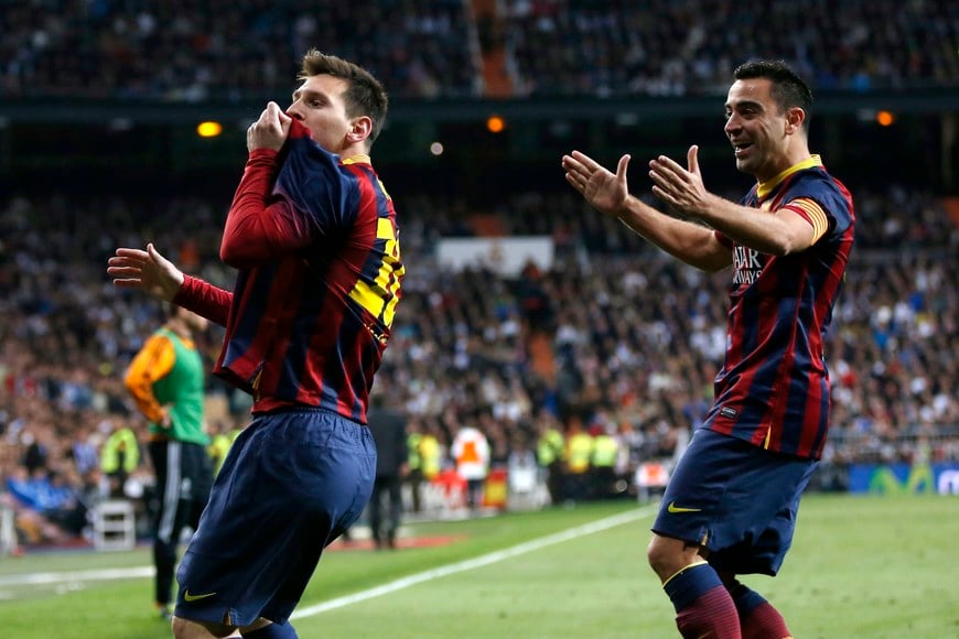 Barcelona's Lionel Messi (L) celebrates with team mate Xavi Hernandez after scoring a penalty goal against Real Madrid during La Liga's second 'classic' soccer match of the season at Santiago Bernabeu stadium in Madrid March 23, 2014 REUTERS/Sergio Perez (SPAIN - Tags: SPORT SOCCER) españa lionel messi Xavi Hernandez campeonato torneo liga española español futbol futbolistas partido barcelona real madrid