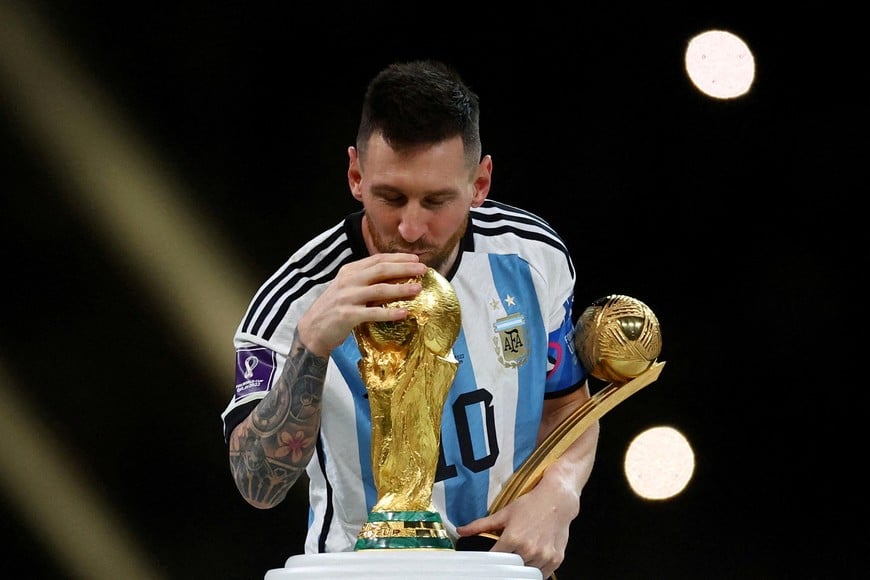 FILE PHOTO: Soccer Football - FIFA World Cup Qatar 2022 - Final - Argentina v France - Lusail Stadium, Lusail, Qatar - December 18, 2022
Argentina's Lionel Messi kisses the World Cup trophy after receiving the Golden Ball award as he celebrates after winning the World Cup REUTERS/Kai Pfaffenbach/File Photo