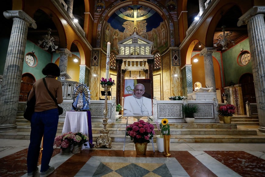 A Christian stands near an image of Pope Francis, after his death was announced by the Vatican, at Chiesa di Santa Maria Addolorata, also known as Church of the Argentines, in Rome, Italy, April 21, 2025. REUTERS/Vincenzo Livieri