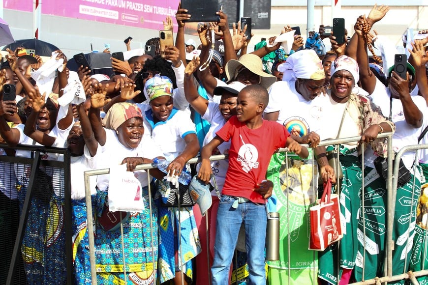 People wave during the arrival of Pope Leo XIV on the streets of Luanda to begin his apostolic journey to Angola, in Luanda, Angola, April 18, 2026. REUTERS/Cesar Muginga