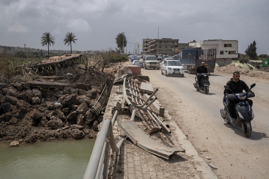 People travel in vehicles as displaced people make their way back to their home crossing the bridge linking southern Lebanon to the rest of the country, which was hit earlier in an Israeli strike, amid a 10-day ceasefire between Lebanon and Israel, in Qasmiyeh, Lebanon, April 19, 2026. REUTERS/Marko Djurica     TPX IMAGES OF THE DAY