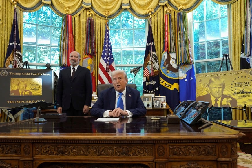 U.S. President Donald Trump looks on as he sits next to a sign that reads "Trump Gold Card is here", in the Oval Office at the White House in Washington, D.C., U.S., September 19, 2025. REUTERS/Ken Cedeno
     TPX IMAGES OF THE DAY
