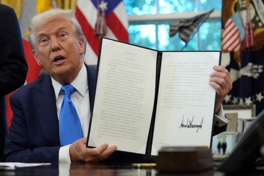 U.S. President Donald Trump displays a signed executive order on gold card visa in the Oval Office at the White House in Washington, D.C., U.S., September 19, 2025. REUTERS/Ken Cedeno     TPX IMAGES OF THE DAY
