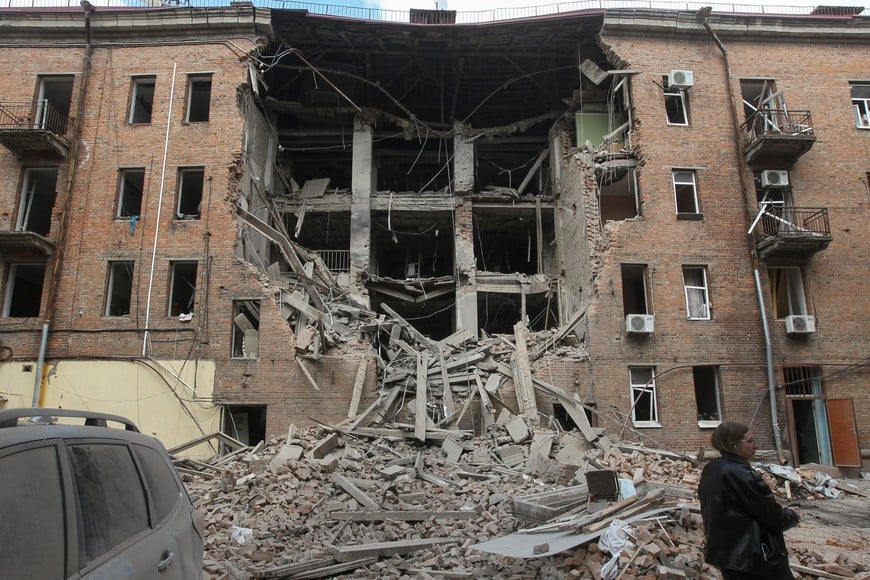 A resident stands in front of a residential building hit during a midday Russian drone strike, amid Russia's attack on Ukraine, in Dnipro, Ukraine April 25, 2026. REUTERS/Stringer