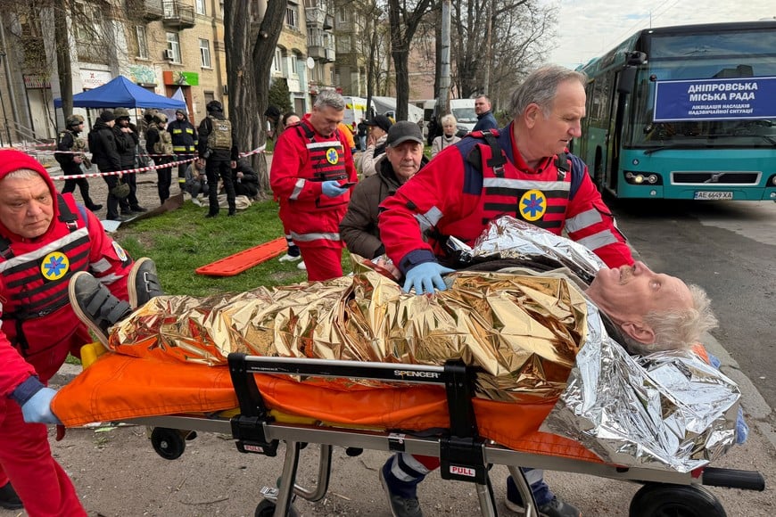 Medical workers evacuate a wounded resident at a site of an apartment building hit by a Russian drone and missile strike, amid Russia's attack on Ukraine, in Dnipro, Ukraine April 25, 2026. Picture taken using a mobile phone. REUTERS/Serhii Chalyi