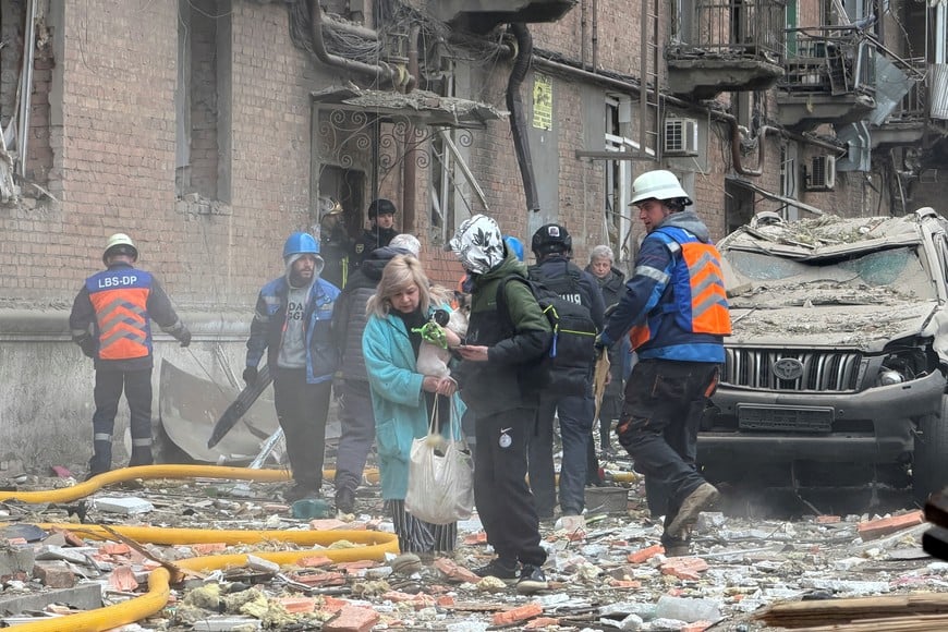 Residents leave the site of an apartment building hit by a Russian drone and missile strike, amid Russia's attack on Ukraine, in Dnipro, Ukraine April 25, 2026. Picture taken using a mobile phone. REUTERS/Serhii Chalyi     TPX IMAGES OF THE DAY