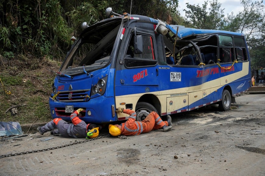 Workers prepare to tow a damaged bus after an attack with explosives that killed over a dozen people on the Pan-American Highway in the El Tunel area of Cajibio, Colombia, April 26, 2026. REUTERS/Jair Coll