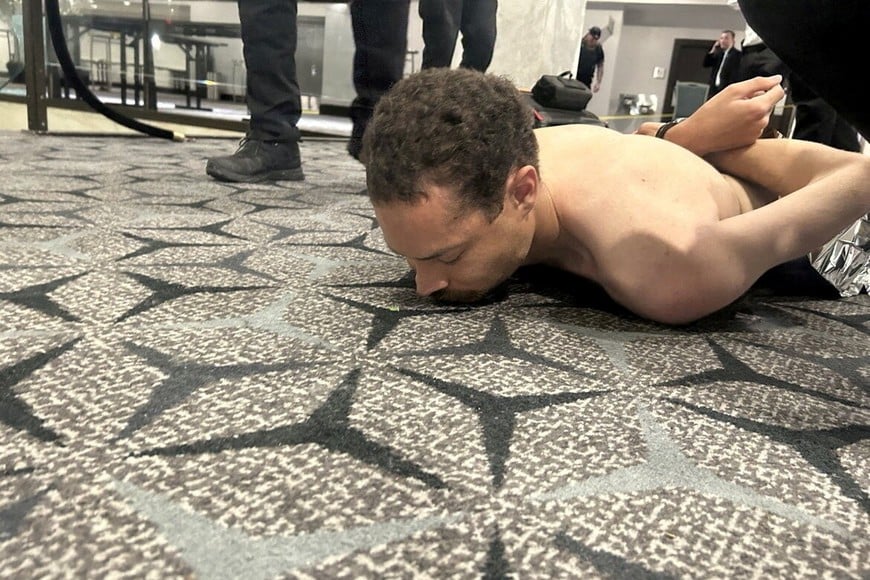 Law enforcement personnel detain Cole Tomas Allen, a suspect in the shooting incident at the White House Correspondents' Association dinner, in Washington, D.C., U.S. April 25, 2026. DONALD J TRUMP via Truth Social/Handout via REUTERS    THIS IMAGE HAS BEEN SUPPLIED BY A THIRD PARTY. MANDATORY CREDIT. REFILE - ADDING NAME OF THE SUSPECTED SHOOTER

VERIFICATION:
Reuters was able to verify the location from flooring and windows that match corroborating footage. Date confirmed from the government statement of the incident. No old results were posted online before April 25. FBI confirmed that National Capital Response Squad has responded to a shooting at the Washington Hilton and added that the subject is in custody.